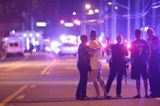Orlando Police officers direct family members away from a fatal shooting at Pulse Orlando nightclub in Orlando, Fla., Sunday, June 12, 2016. AP Photo/Phelan M. Ebenhack
