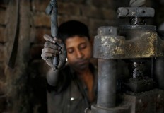 In this Sunday, June 12, 2016, photo, Abdullah, 12, works at a metal factory in Dhaka, Bangladesh. AP Photo/ A.M. Ahad