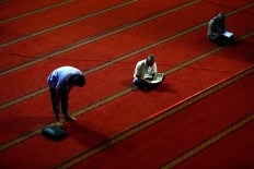 A man prays while others recite the Quran during Ramadhan at the Istiqlal Grand Mosque in Central Jakarta on June 9. JP/ Wienda Parwitasari