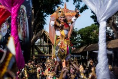 A Balinese dancer stands on the shoulders of other dancers during the street parade.  JP/Agung Parameswara