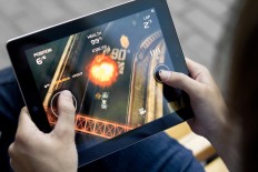  A man plays the game Death Rally on an iPad.