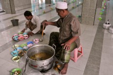 A cook adds lamb curry soup to bubur India. JP/ Albertus Magnus Kus Hendratmo