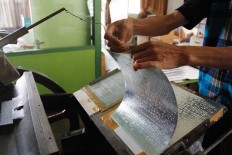 Wasca replaces a zinc plate that has braille letters on it before printing the Quran in braille. JP/Arya Dipa