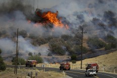 Fire trucks move along Highway 178 near Lake Isabella, Calif., Friday, June 24, 2016, as a wildfire continues to burn in the area. The wildfire that roared across dry brush and trees in the mountains of central California gave residents little time to flee as flames burned homes to the ground, propane tanks exploded and smoke obscured the path to safety. AP Photo/Jae C. Hong