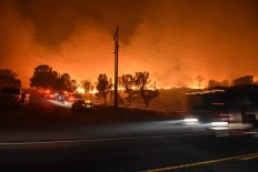A Kern County firefighter sets a backfire by a wildfire burning near Lake Isabella, Calif. on Friday, June 24, 2016.  Dozens of homes burned to the ground as a wildfire raged over ridges and tore through rural communities in central California, authorities said. Ryan Babroff via AP