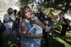 Evacuee Kimberly Tieche holds her 10-month old puppy while listening to the briefing on a wildfire at an evacuation center, Saturday, June 25, 2016, near Kernville, Calif. Tieche whose home was devastated by the wildfire said she only had five minutes to get out. AP Photo/Jae C. Hong