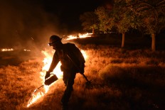 Kern County firefighters move on a fast burning wildfire burning near Yankee Canyon and State Route 178 near Lake Isabella, Calif. on Friday, June 24, 2016.  Dozens of homes burned to the ground as a wildfire raged over ridges and tore through rural communities in central California, authorities said. Ryan Babroff via AP
