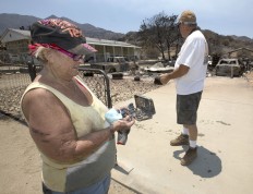 Sallie Keeling looks through a jewelry box she found after she and her husband, Steve, right, searched through the burned out rubble of their home, Monday, June 27, 2016, in South Lake, Calif. The home was destroyed by the fire that started Thursday, near Lake Isabella, Calif. AP Photo/Rich Pedroncelli
