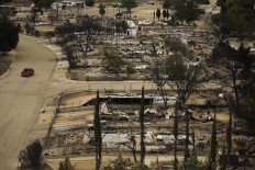 A pickup truck passes by the remains of mobile homes devastated by a wildfire, Saturday, June 25, 2016, in South Lake, Calif. Gov. Jerry Brown declared a state of emergency, freeing up money and resources to fight the fire and to clean up in the aftermath. The Federal Emergency Management Agency also authorized the use of funds for firefighting efforts. AP Photo/Jae C. Hong