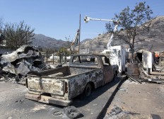 The burned out remains of a pickup are seen as power crews work to restore power in fire ravaged South Lake, Calif, Monday, June 27, 2016. The fire that started Thursday, near Lake Isabella, Calif has taken the lives of an elderly couple, apparently overcome by smoke, burned more than 70 square miles, and is 40 percent contained. AP Photo/Rich Pedroncelli