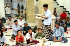 A man is prepares a nasi tumpeng plate inside the Muhajirin Mosque for people to break their fast. JP/Zul Trio Anggono