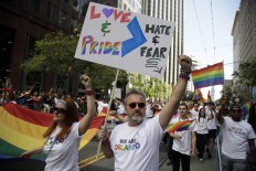 Todd Elmer, center, and, Rachel Payne, left, march during the San Francisco Gay Pride parade Sunday, June 26, 2016, in San Francisco. Parades in San Francisco and other major cities Sunday featured increased security, anti-violence messages and tributes to those killed in this month's massacre at a gay nightclub in Florida. AP Photo/Marcio Jose Sanchez
