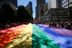 People help carry the rainbow flag during the the 42nd annual Seattle Pride Parade on Sunday, June 26, 2016. Sophia Nahli Allison/The Seattle Times via AP
