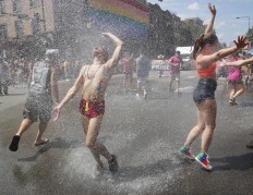 Participants cool off in a spray of water from a Chicago Fire Department hose at the 47th annual Chicago Pride parade on Sunday, June 26, 2016 in Chicago. Michael Tercha/Chicago Tribune via AP