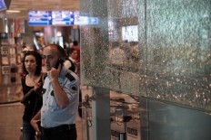 A security guard stands next to a broken window inside Ataturk Airport in Istanbul, Wednesday June 29, 2016. AP Photo/Bram Janssen