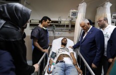 Turkish Prime Minister Binali Yildirim, second right, visit a wounded man at a hospital in Istanbul, Wednesday, June 29, 2016. Hakan Goktepe, Prime Ministry Press Office