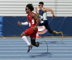 In this Friday, July 1, 2016 photo, Paul Petterson, front, and Trenten Merrill, back, race in their heat in the men's 100-meter dash during the U.S. Paralympics Team Trials in Charlotte, N.C. AP Photo/Chuck Burton