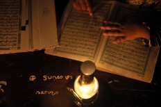 Students recite the Quran with modest lighting. JP/ Ganug Nugroho Adi