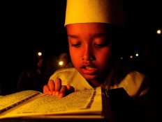 A young student solemnly recites the Quran during an odd night in the last 10 days of Ramadhan. JP/Ganug Nugroho Adi