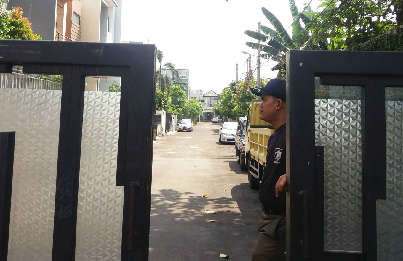 A security guard stands at the gate of a housing complex located in Palmerah, West Jakarta, on Thursday.
