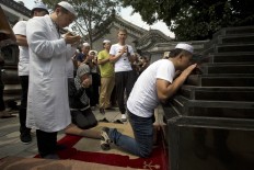 Muslim pray before the Shaykhs tombs, relics from the 13th century, after Eid al-Fitr prayers at the Niujie mosque, the oldest and largest mosque in Beijing, China, Wednesday, July 6, 2016. The Eid al-Fitr celebrations mark the end of the Muslim holy fasting month of Ramadan. AP Photo/Ng Han Guan

