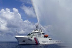 In this Sept. 23, 2015, photo, provided by Filipino fisherman Renato Etac, a Chinese Coast Guard boat sprays a water cannon at Filipino fishermen near Scarborough Shoal in the South China Sea. A landmark ruling on an arbitration case filed by the Philippines that seeks to strike down China's expansive territorial claims in the South China Sea will be a test for international law and world powers. China, which demands one-on-one talks to resolve the disputes, has boycotted the case and vowed to ignore the verdict, which will be handed down Tuesday, July 12, 2016, by the UN tribunal in The Hague.