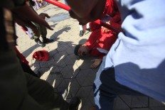 Officers help a royal guard who apparently tripped and tumbled to the ground during the procession. (JP/Dhoni Setiawan)
