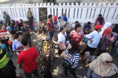 Residents wait for the pyramid offerings, known as gunungan, being paraded out from the Yogyakarta Palace to designated places. (JP/Dhoni Setiawan)

