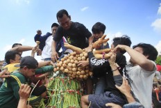 People scramble for Grebeg Syawal offerings that symbolize the sultan’s care and blessings shared with the people. (JP/Dhoni Setiawan)

