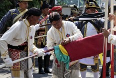 Palace guards tidy up a flag pole after the Grebeg Syawal procession at the Yogyakarta Palace. (JP/Dhoni Setiawan)