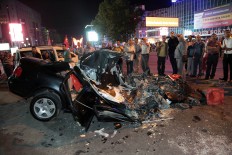 People gather around a damaged car which was crashed by a tank in Kizilay Square to protest against a military coup in Ankara, Turkey, early Saturday, July 16, 2016. Turkish President Recep Tayyip Erdogan told the nation Saturday that his government was working to crush a coup attempt after a night of explosions, air battles and gunfire across the capital. AP Photo/Burhan Ozbilici