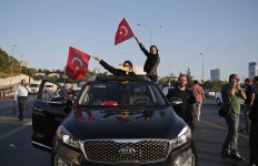 Turkish people wave the national flags on a car in Istanbul, Turkey, Saturday, July 16, 2016. Turkish President Recep Tayyip Erdogan, speaking on national television from Istanbul, told the nation Saturday that his government was working to crush a coup attempt after a night of explosions, air battles and gunfire across the Turkish capital of Ankara. AP Photo/Emrah Gurel
