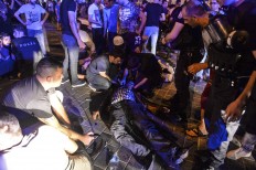 People attend to a man that was protesting against the coup, laying wounded when Turkish forces soldiers opened fire to disperse the crowd, in Istanbul's Taksim square, early Saturday, July 16, 2016. Members of Turkey's armed forces said they had taken control of the country, but Turkish officials said the coup attempt had been repelled early Saturday morning in a night of violence, according to state-run media. AP Photo/Selcuk Samiloglu