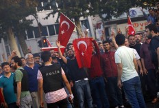 People, loyal to the government, some holding Turkish flags celebrate in Istanbul, Saturday, July 16, 2016.  Turkish President Recep Tayyip Erdogan declared he was in control of the country early Saturday as government forces fought to squash a coup attempt during a night of explosions, air battles and gunfire that left dozens dead. AP Photo/Emrah Gurel