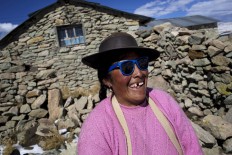 In this July 9, 2016 photo, Cecilia Callo Mamani laughs as her neighbors joke about her sunglasses in San Antonio de Putina in the Puno region of Peru. Mamani said she wears them to protect her eyes from the snow's strong reflection. AP Photo/Rodrigo Abd