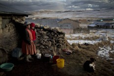 In this July 9, 2016 photo, Rosa Carcabusto and her daughter Maria Luque stand outside their home before cooking a dinner soup of wheat and dried potatoes, in San Antonio de Putina in the Puno region of Peru. Poverty has driven many farmers' children from their homes to work in illegal mines or Peru's flourishing cocaine trade. AP Photo/Rodrigo Abd