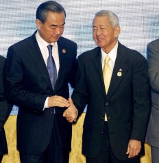 China's Foreign Minister Wang Yi (left) stands with Philippines Foreign Minister Perfecto Yasay Jr. after they pose for a photo during the Association of Southeast Asian Nations (ASEAN) Foreign Ministers' Meeting in Vientiane, Laos, July 26.