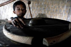 A boy plays with a Wukir string instrument called Luku and Garu. The instrument, which produces natural sounds, is played at many international events. JP/ Albertus Magnus Kus Hendratmo