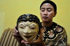 Nani, a Losari mask dancer, holds a 300-year-old wooden mask. JP/ Albertus Magnus Kus Hendratmo
