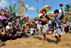 Photographers take pictures of two dancers during the Five Mountain Festival. JP/Albertus Magnus Kus Hendratmo

 