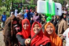 Residents take a selfie with traditional Jingkrak Sundang dancer during the festival. JP/Albertus Magnus Kus Hendratmo