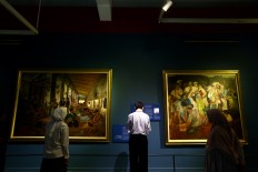 People look at a painting by S. Sudjojono (left) and another by Dullah (right) from the historical collection. The Jakarta Post/Wienda Parwitasari