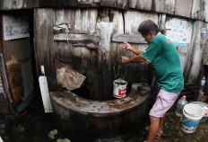 Nio Koen Hing takes water from an old well. JP/ Tarko Sudiarno