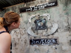 A foreign tourist looks at a clock that melted in the eruption, on display at the Mini Museum complex in Petung village, Cangkringan, 7 kilometers away from the peak of the mountain. JP/ Agus Maryono
