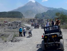Tourists stand in a jeep provided by a tourist agency in Sleman as they arrive in Kaliadem. As the area nearest the volcano, the village was badly affected by the eruption. JP/ Agus Maryono
