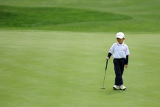 A boy competes in a golf match for children in Zhengzhou, Henan province, on April 19, 2014. 