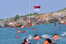About 600 participants of a ceremony on Baron Beach in Gunung Kidul, Yogyakarta, swim 200 meters from the beach to hoist flags at sea. The event was organized by Baron’s search and rescue team and saw the participation of many locals. JP/ Alb Magnus Kus Hendratmo
