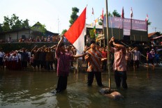 Residents of Tejokusuman in Ngampilan, Yogyakarta, hold an Independence Day ceremony on the Winongo River, Wednesday. It was the first time residents held the ceremony in the river, which they did to maintain harmony between the riverbank people and the river. JP/ Aditya Sagita