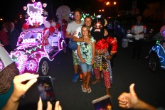 A family of foreign tourists pose with a man dressed as a wayang character during the festival. JP/ Aditya Sagita