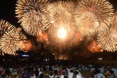 People sit on mats on the edge of Biwa Lake to enjoy fireworks. JP/Tarko Sudiarno